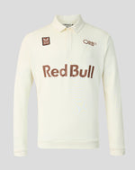 An off-white long-sleeve polo shirt with a brown 'Red Bull' logo across the chest, an 'ORB' logo on the right chest, and a small sponsor patch on the left chest, shown on a neutral gray background.