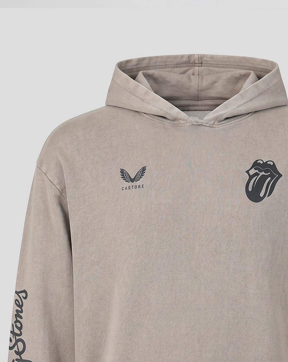 A close-up of a beige hooded sweatshirt featuring the Rolling Stones logo on the left chest and a winged crest with 'CASTORE' text on the right chest, on a light gray background.
