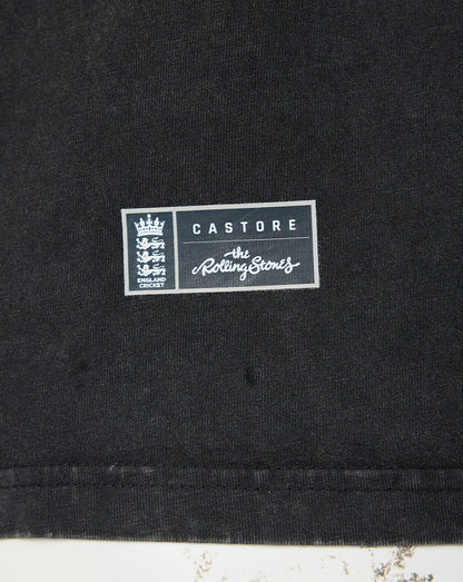 Close-up of a black fabric garment with a rectangular white and gray printed patch reading 'CASTORE' and 'The Rolling Stones' with the band's crest on the left.