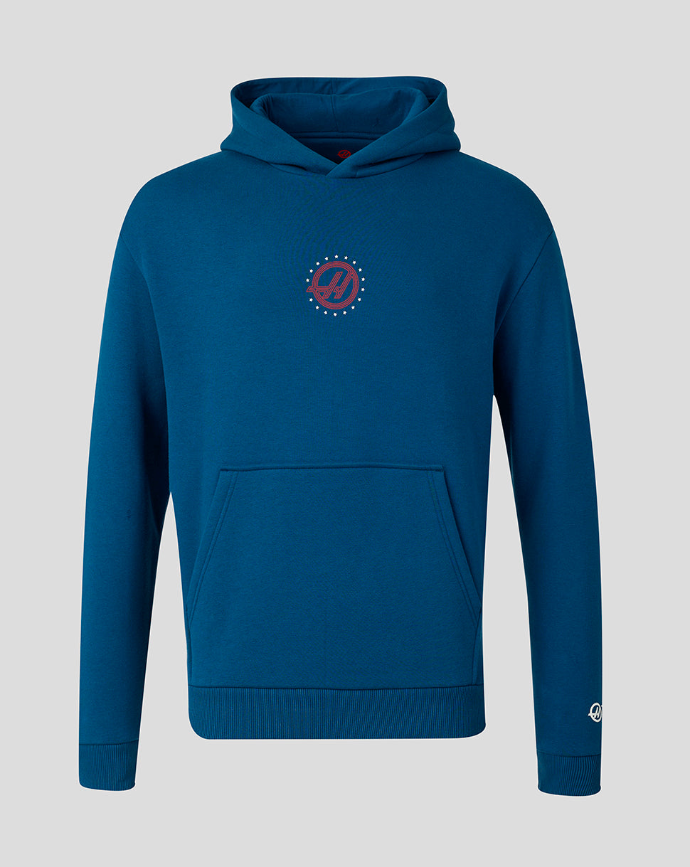 A dark teal blue pullover hoodie with a small circular red and white graphic on the left chest, displayed on a neutral gray background.