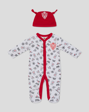 Red baby hat with crest alongside a white babygrow printed with football icons.