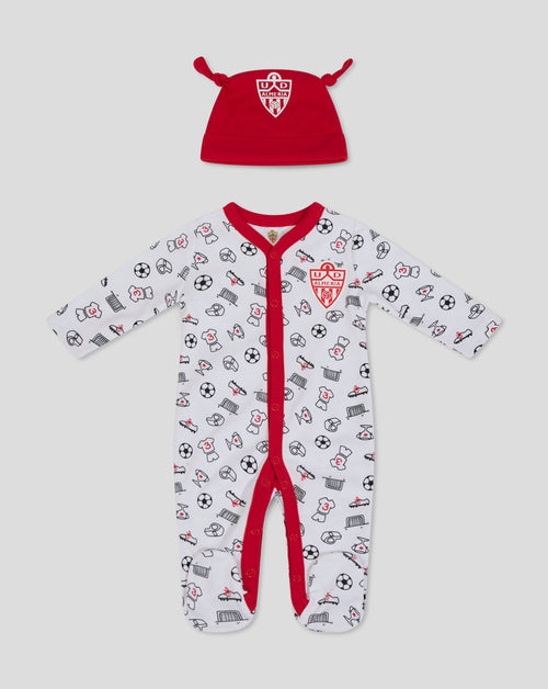 Red baby hat with crest alongside a white babygrow printed with football icons.