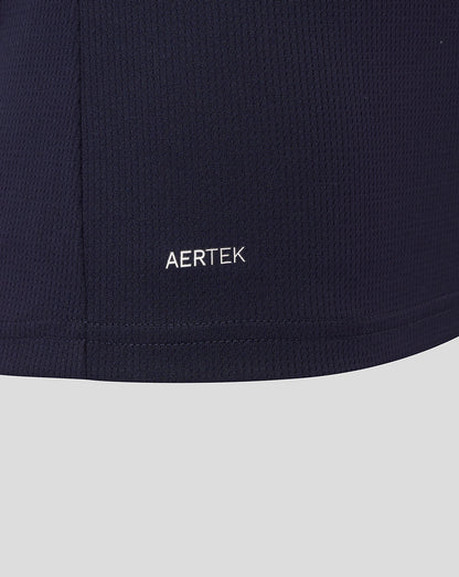 Close-up of AerTek logo on navy fabric near the hem of the shirt