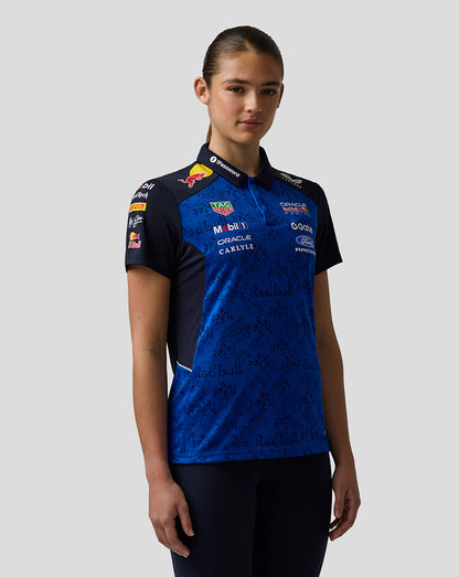 Person wearing a blue and black sports jersey with various sponsor logos on a gray background