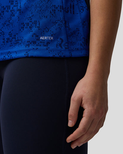 Person wearing a blue athletic top with black pattern and black pants, brand 'AERTEK' visible.