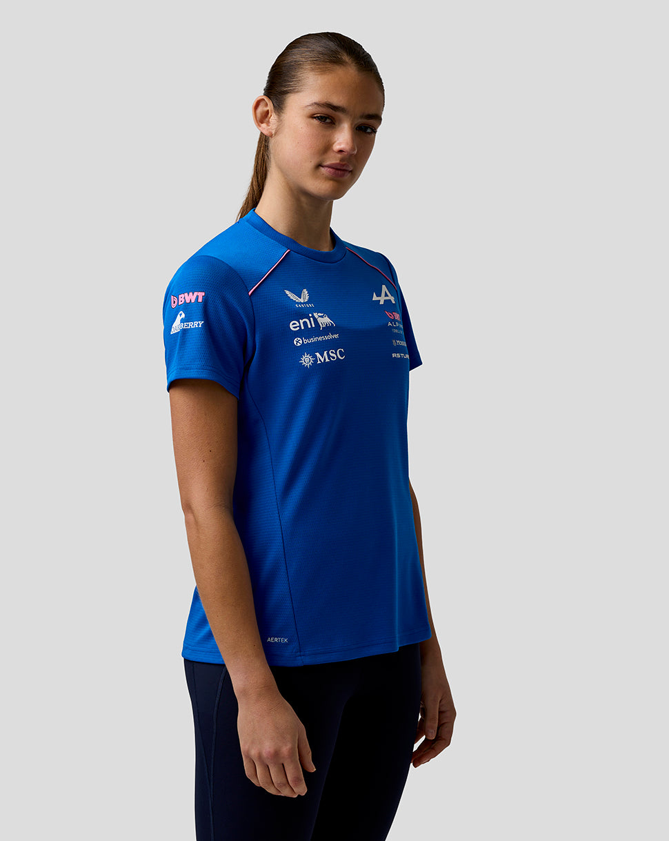 Female model wearing blue BWT Alpine Set Up shirt with sponsor logos and pink contrast piping.