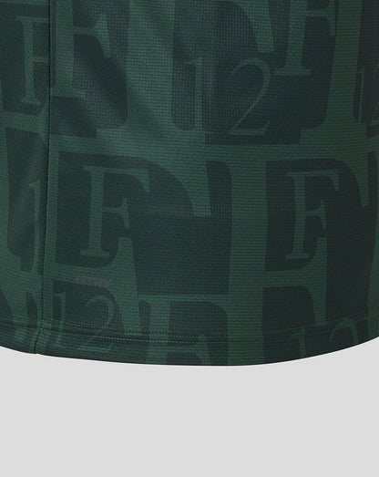 Close up of dark green Twelfth shirt fabric showing an allover pattern and Authentic Castore Product badge at the hem.