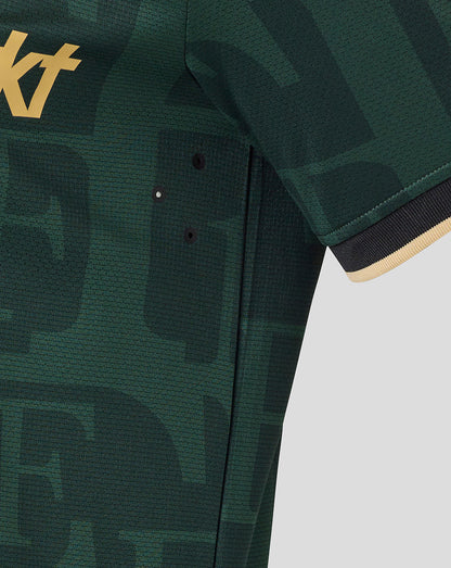 Close-up of dark green Twelfth Shirt sleeve with beige gold trim and side ventilation eyelets on a camo pattern.