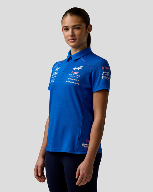 Three-quarter view of a woman in a blue BWT Alpine polo with team logos and concealed zip