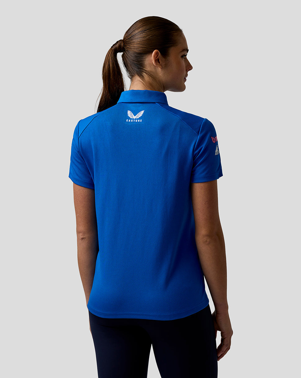Back view of a woman in a blue BWT Alpine polo highlighting the Castore logo on the upper back