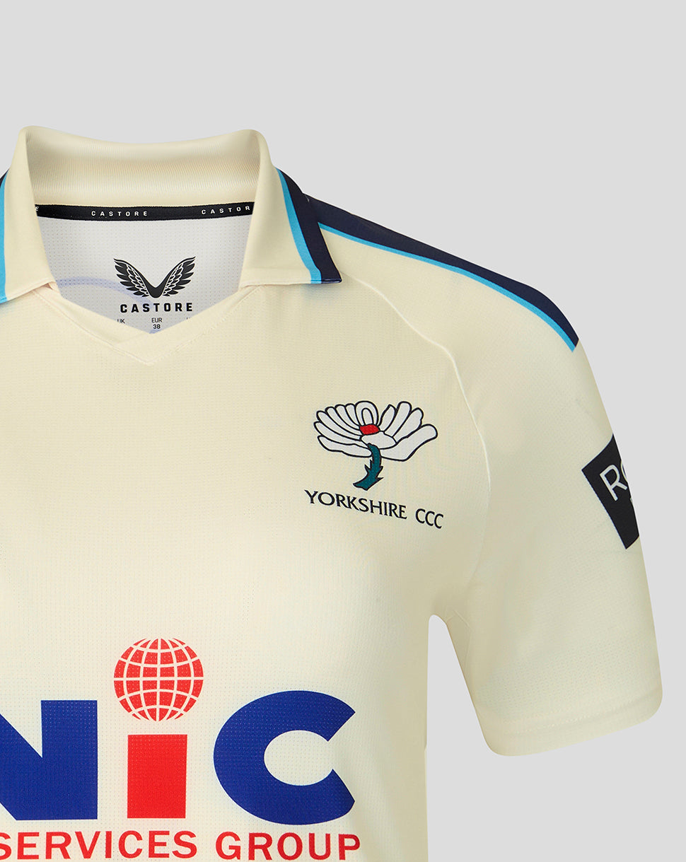 Beige sports jersey with branding and logos on a light gray background