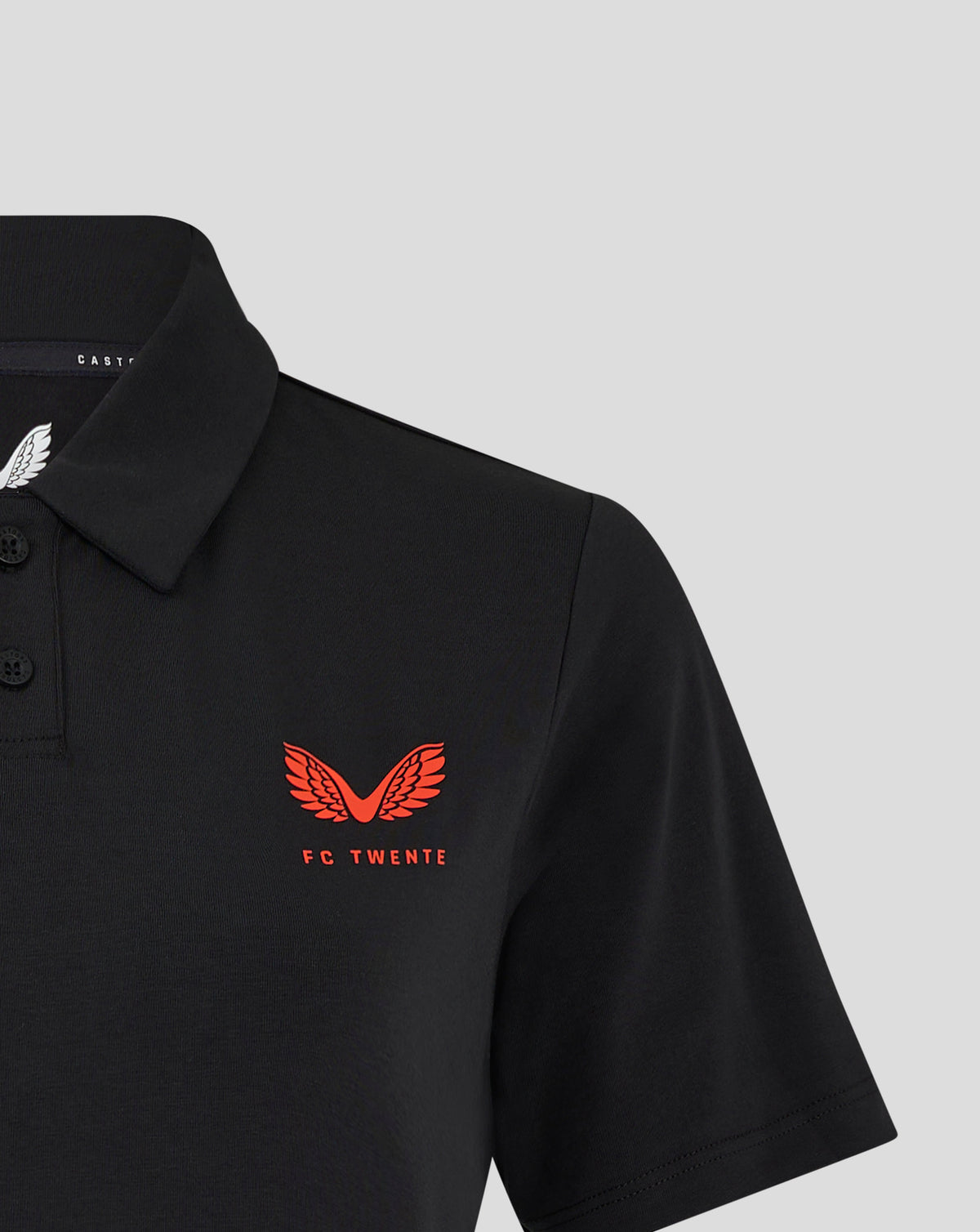 Close-up of black FC Twente Travel Polo showing red wings crest and FC Twente branding on the chest