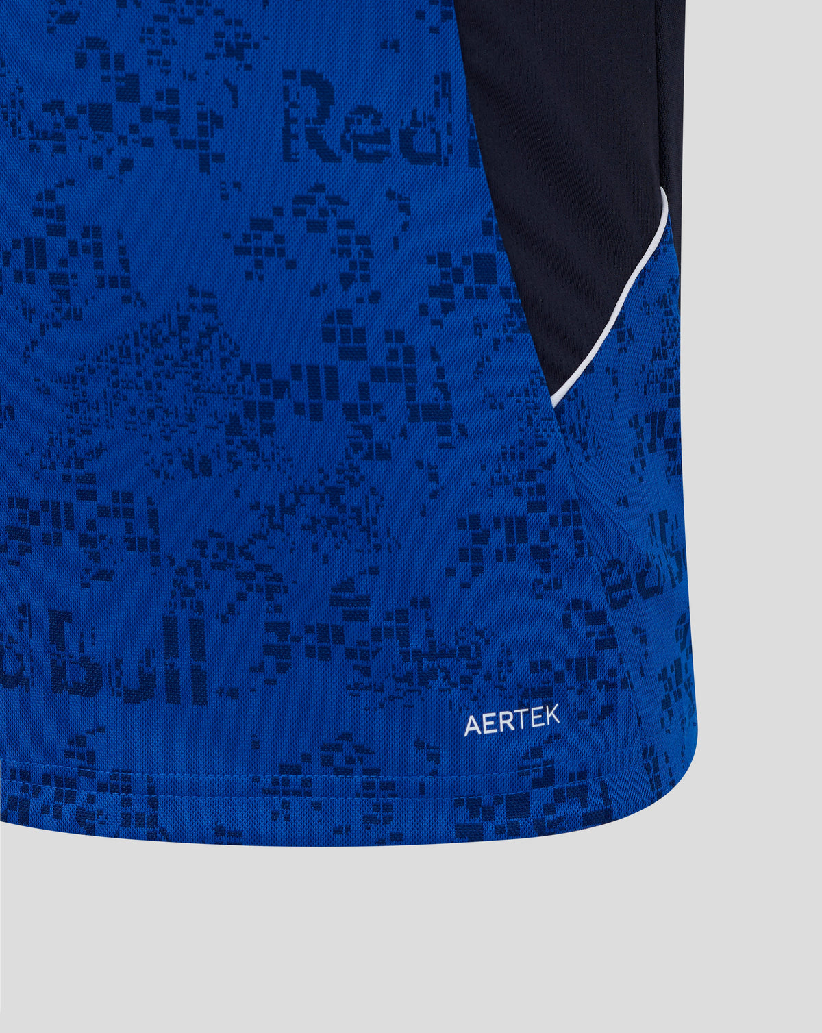 Close-up of a blue athletic garment with a tonal dark blue pixelated pattern, a dark navy side panel, a thin white piping accent, and the word AERTEK near the hem.