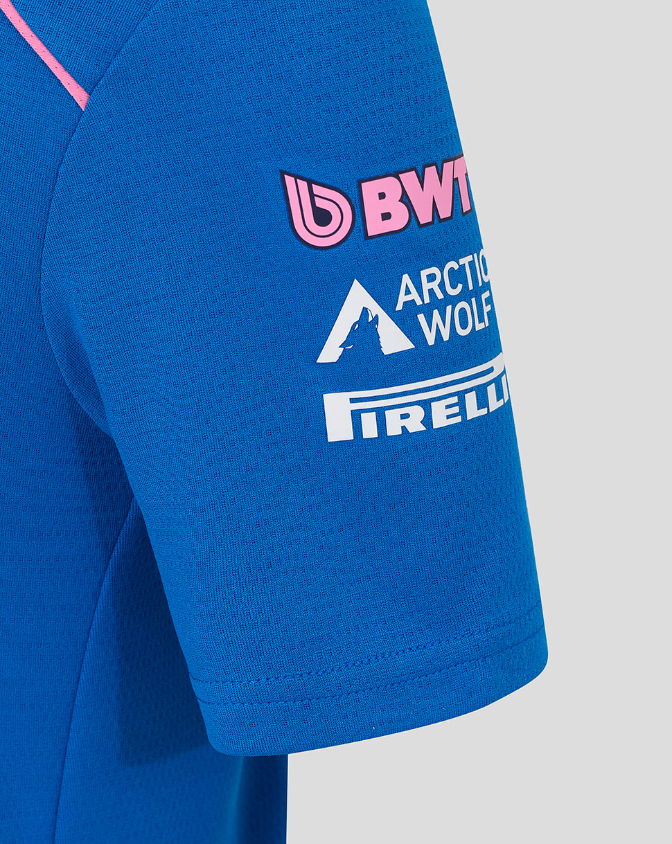 Close-up of sleeve area on blue BWT Alpine polo showing sponsor logos including BWT Arctic Wolf and Pirelli