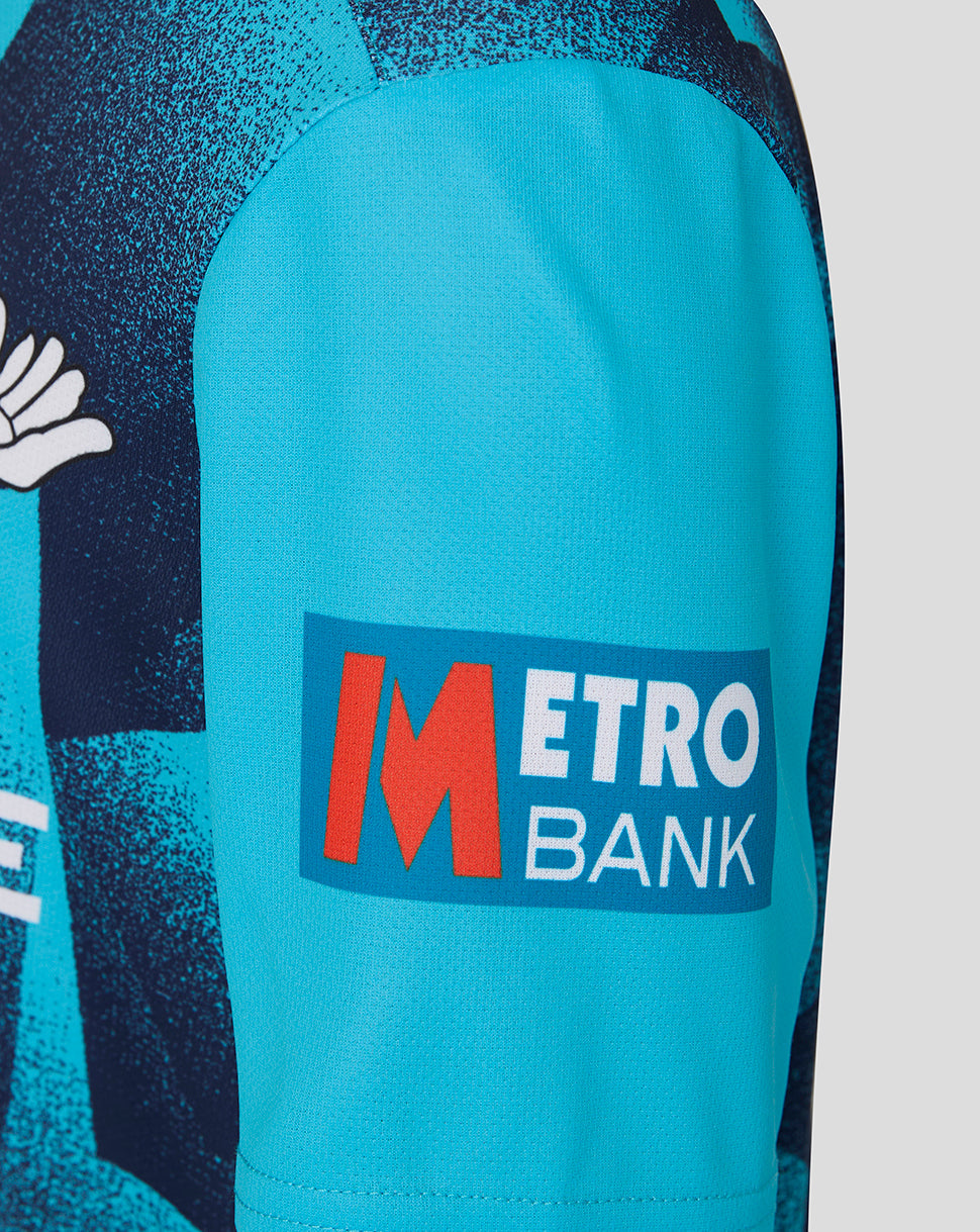 Close-up of a sports jersey with Metro Bank logo on a blue sleeve.