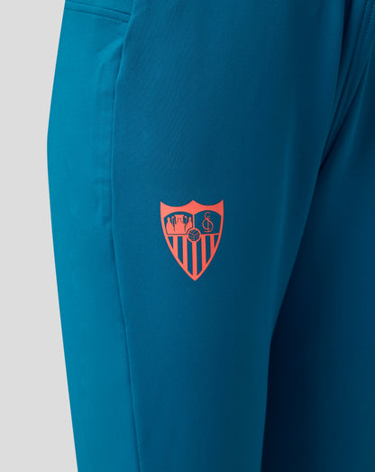 Sevilla FC junior training pants in blue with a pink club crest on the thigh