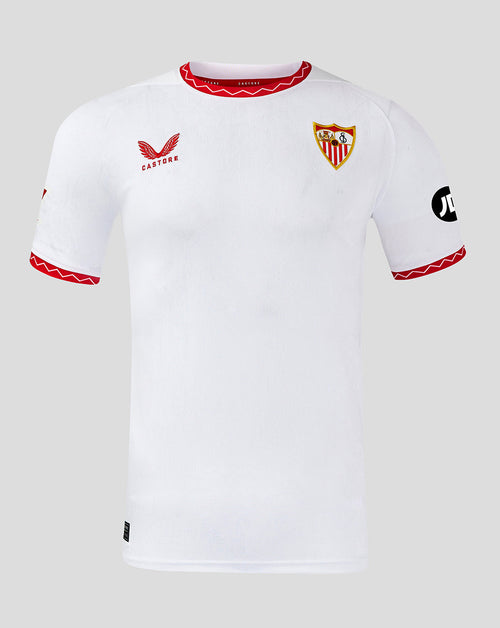 A white short-sleeve soccer jersey with red trim on the collar and cuffs, featuring the Sevilla crest on the left chest, a red bird logo with 'CASTORE' on the right chest, and a black sponsor logo on the right sleeve, shown against a light gray background.