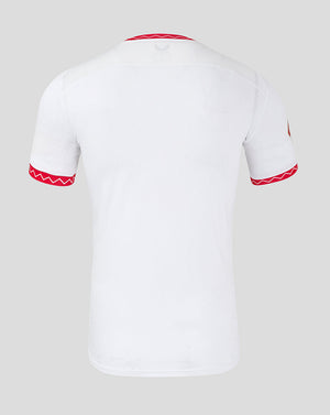White short-sleeve soccer jersey shown from the back, featuring red zigzag trim along the collar and sleeve cuffs.