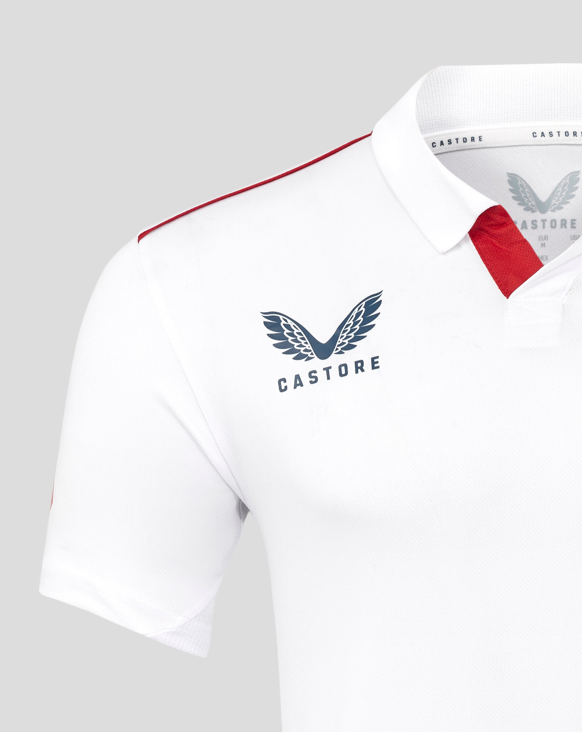 White polo shirt with red accents and Castore logo on a gray background