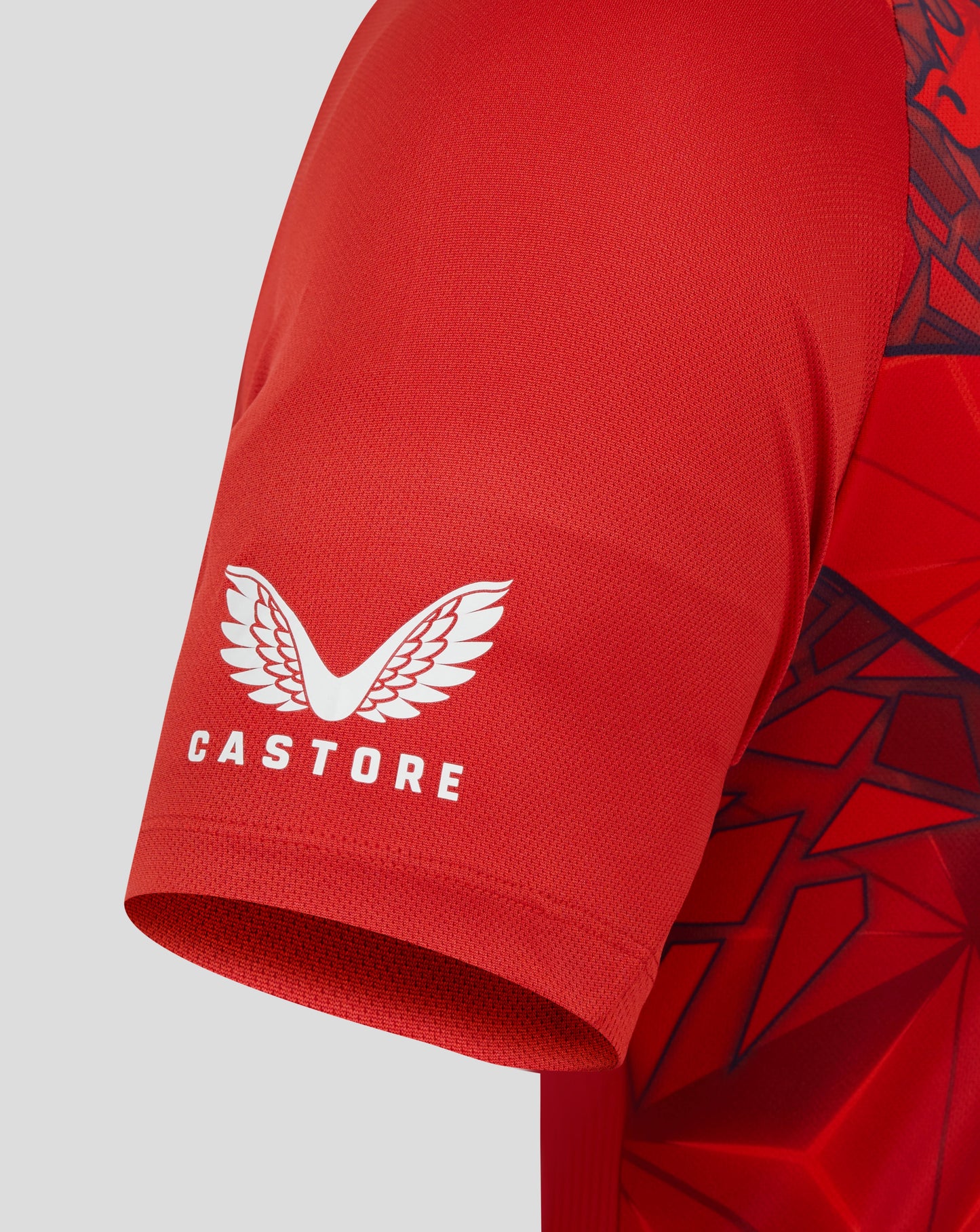 Red sports jersey with Castore logo on a gray background