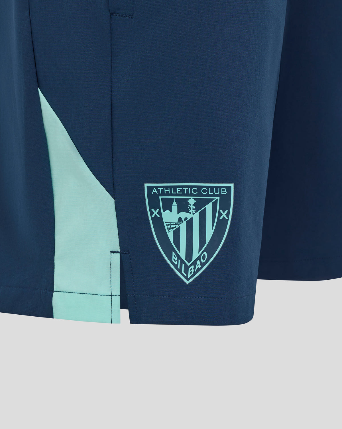 Close-up of navy blue Athletic Club shorts with a light teal side panel and a crest patch.