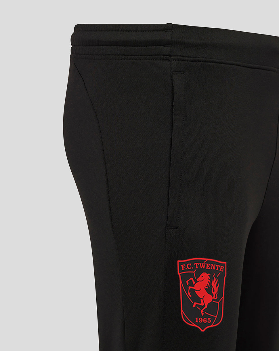 Close up of black FC Twente performance pants with a red crest patch on the leg