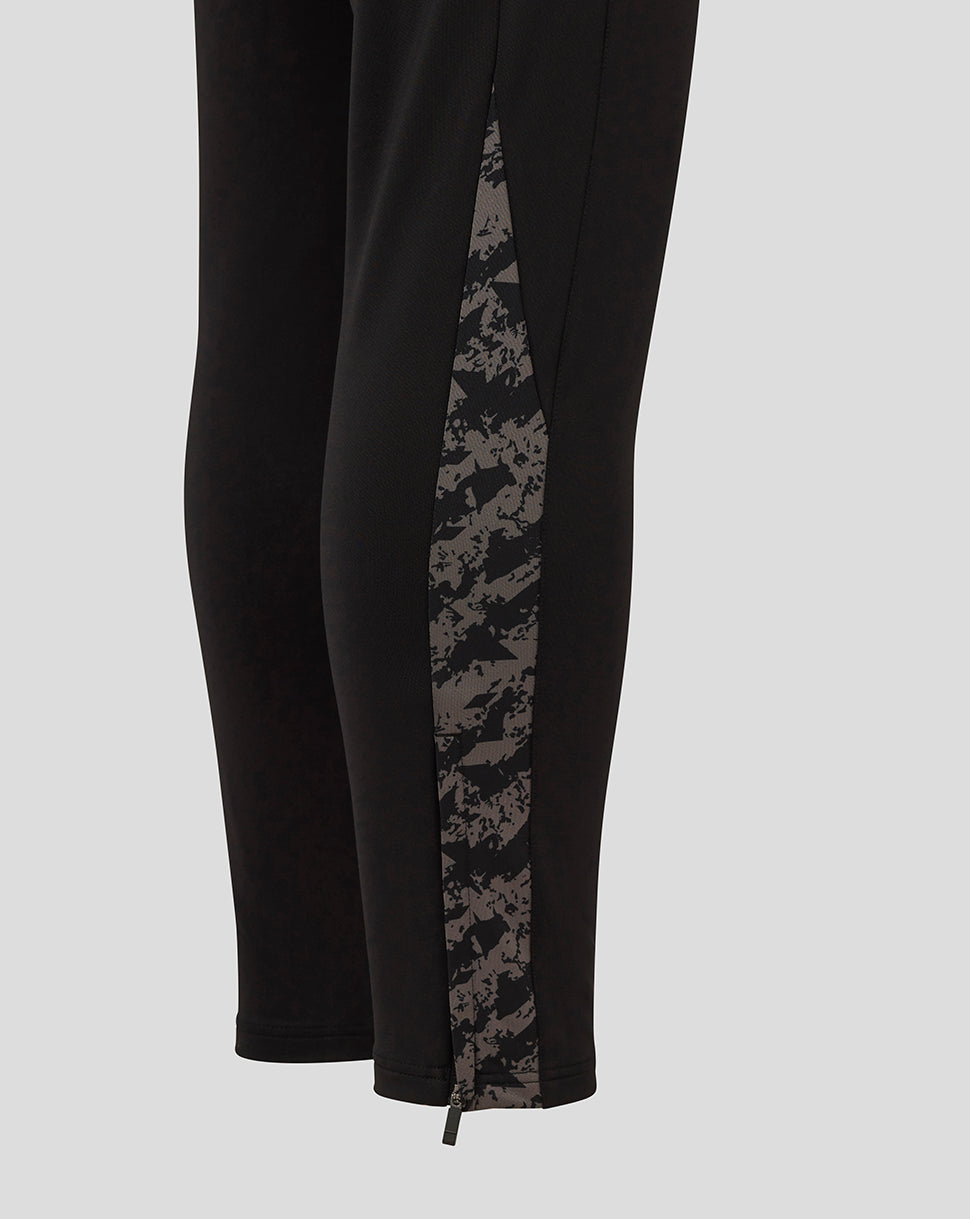 Side view of black FC Twente pants featuring a gray camo panel and zip at the hem