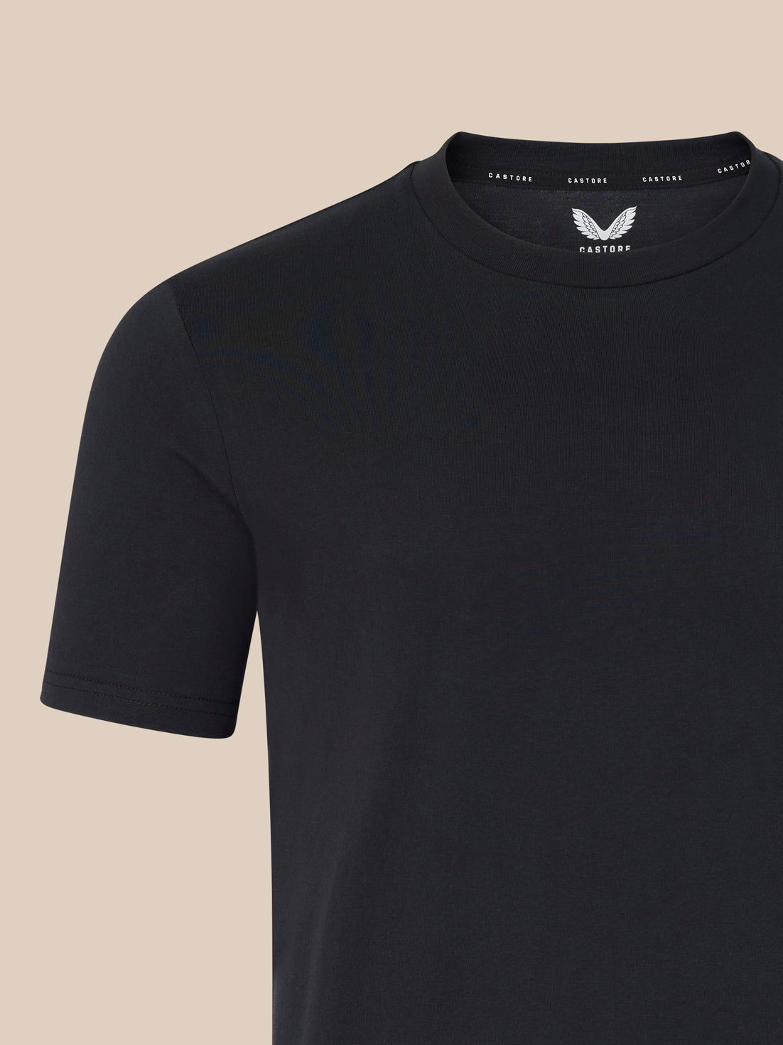 Black t-shirt with a brand logo on a beige background
