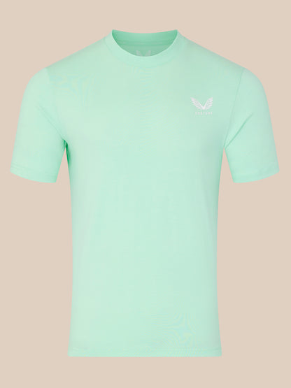 Mint green t-shirt with a small logo on a beige background