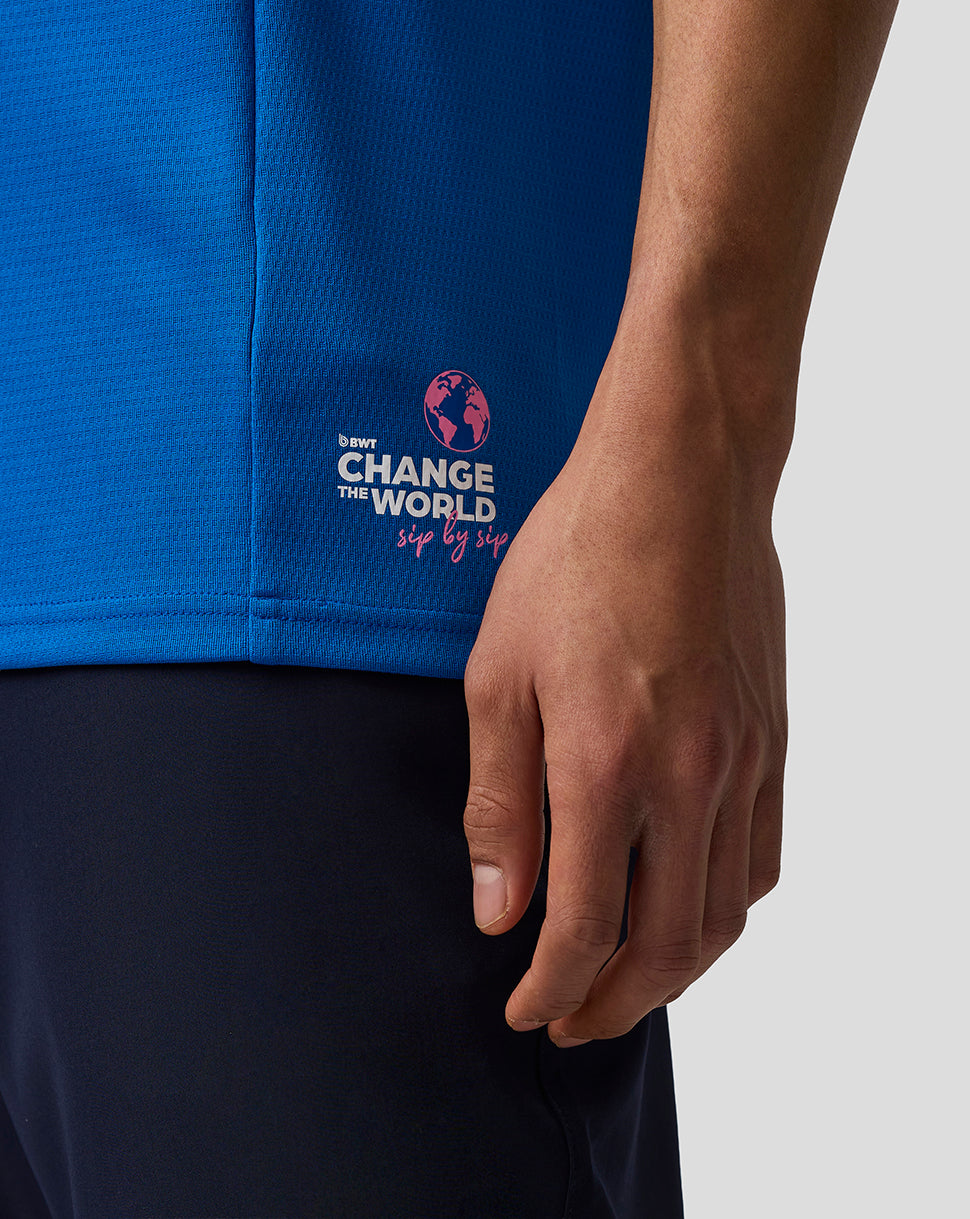 Blue shirt with a logo and text on a person wearing it, against a neutral background