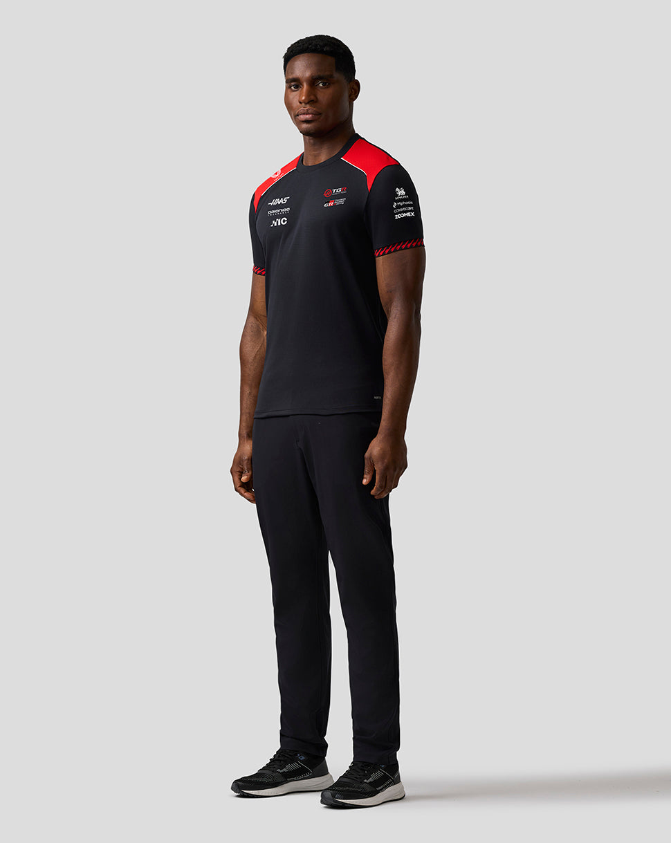 Person wearing a black and red sports outfit on a light gray background