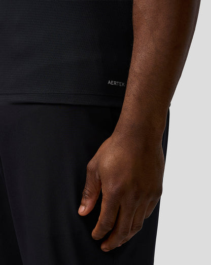 Person wearing a black outfit with 'AERTEK' branding on a neutral background