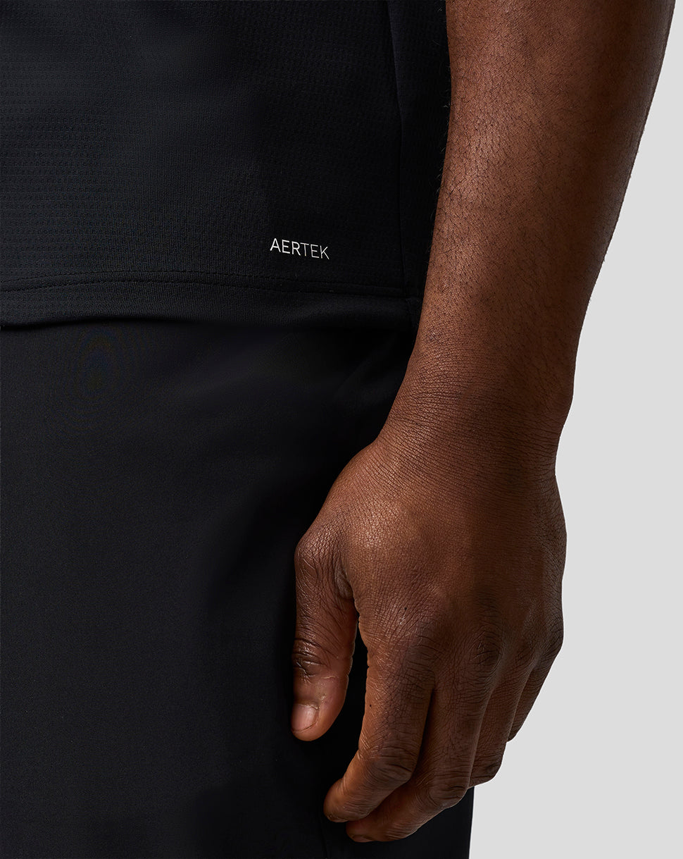 Close-up of a person wearing a black garment with 'AERTEK' branding.