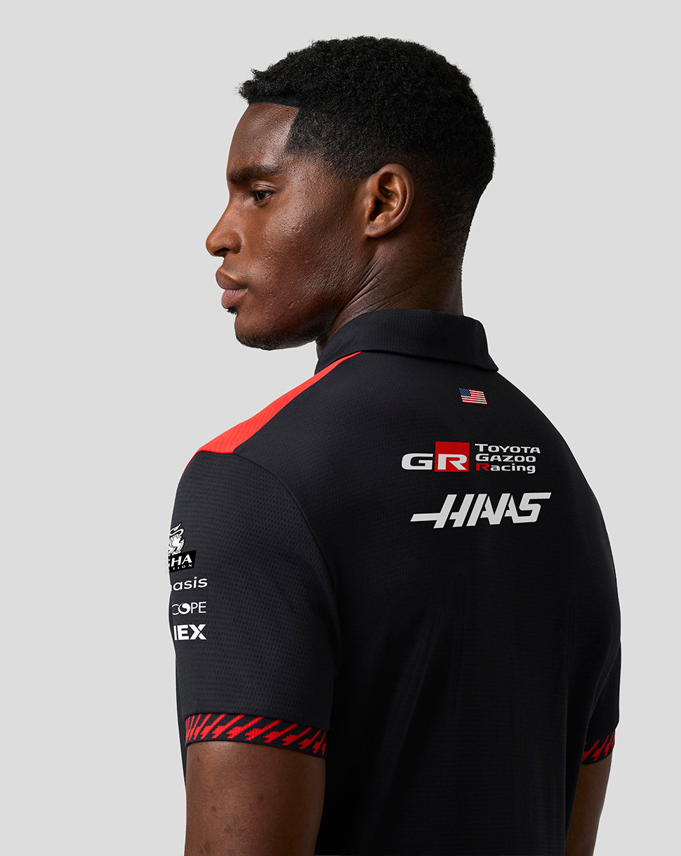 Person wearing a black polo shirt with Toyota Gazoo Racing and Haas logos on a gray background