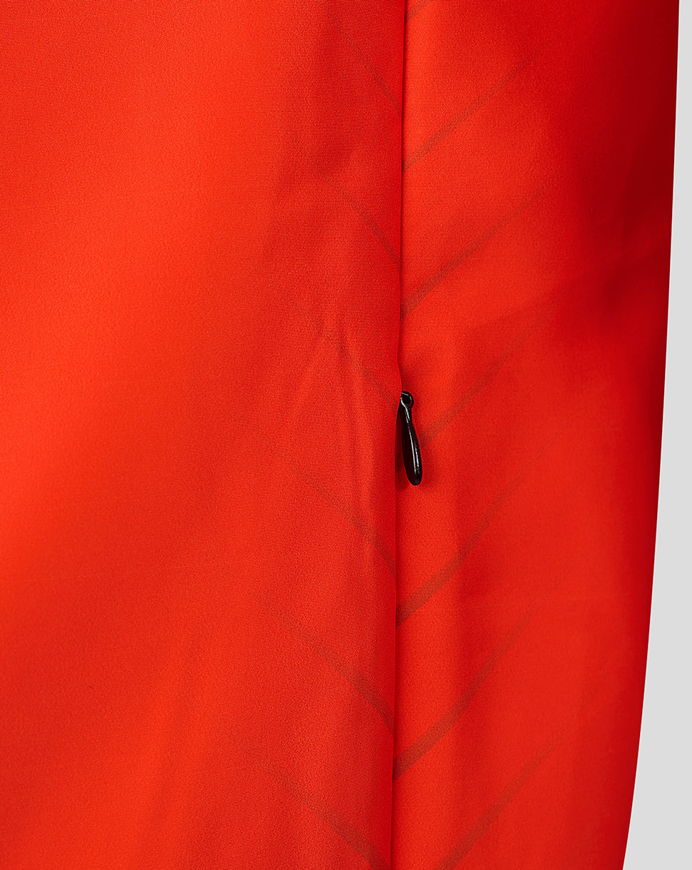 Close up of orange jacket fabric with a vertical zipper and diagonal stitching details