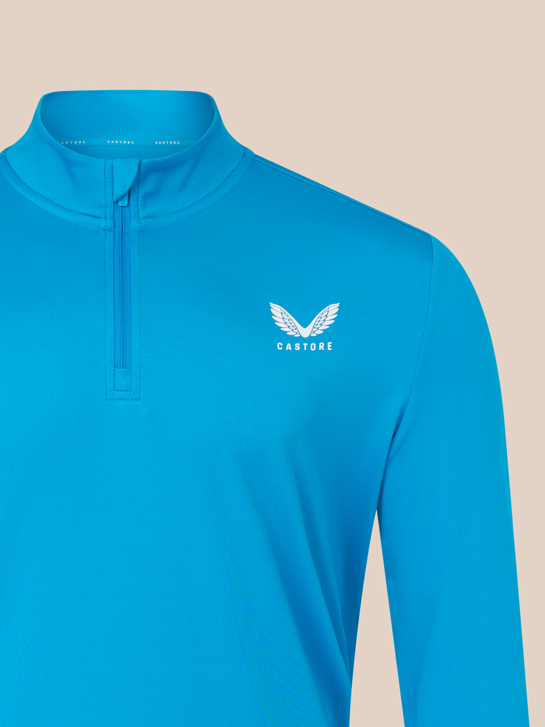 Blue long-sleeve shirt with a logo on a beige background