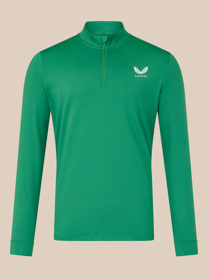 Green long-sleeve shirt with a brand logo on a beige background