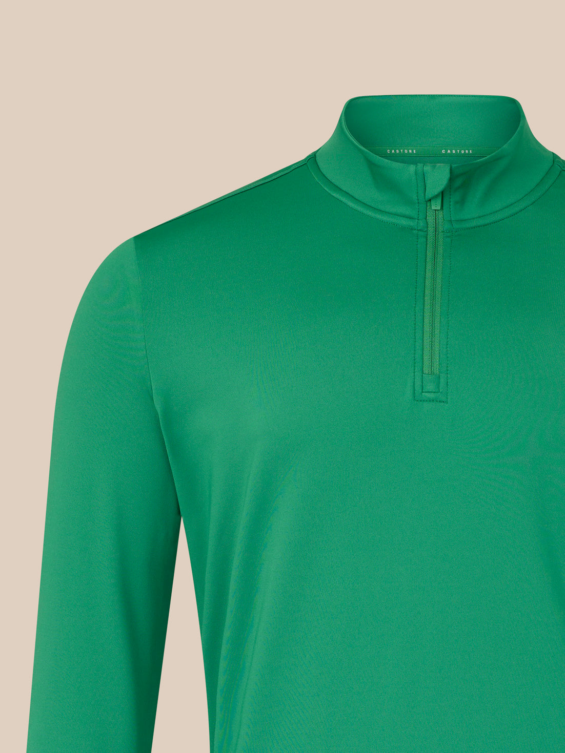Green long-sleeve shirt with a quarter zip on a beige background