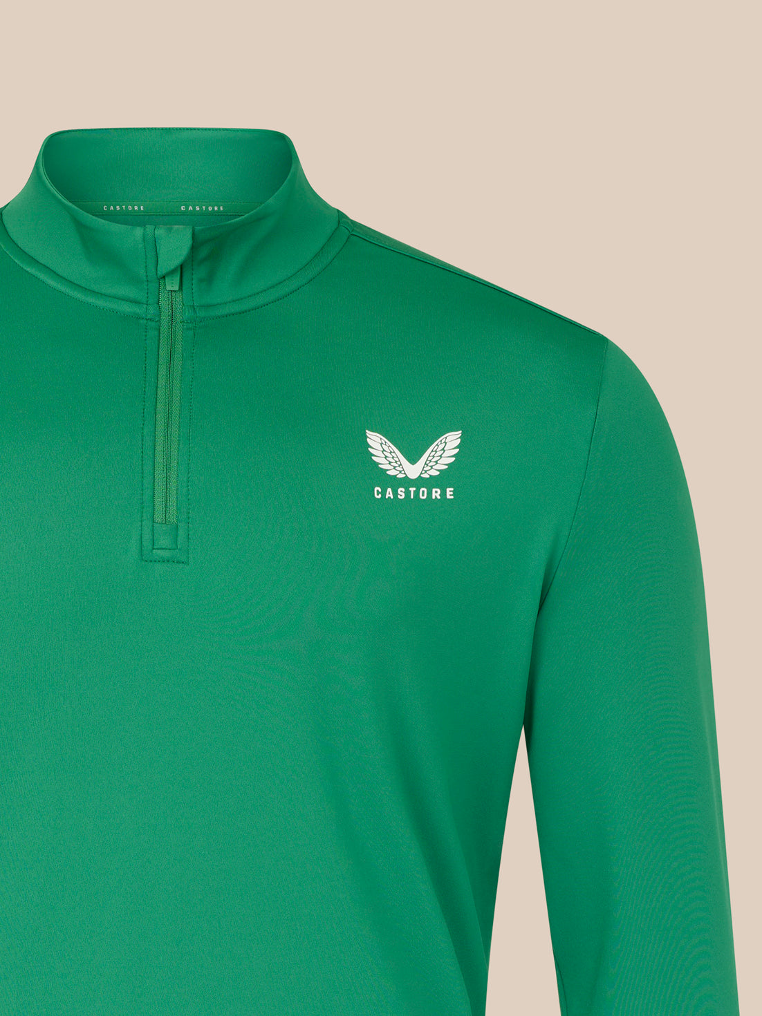 Green long-sleeve shirt with a white logo on a beige background