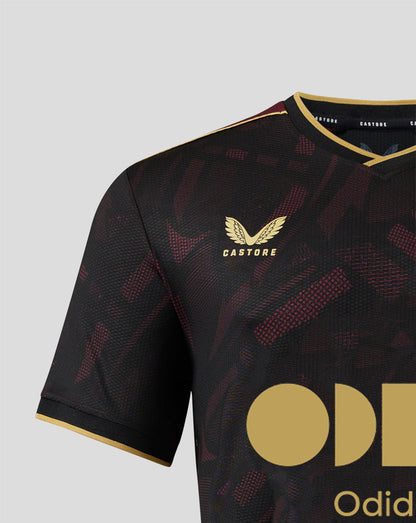 Upper chest view of FC Utrecht junior away shirt showing the gold Castore logo and the club crest on the left against the dark pattern