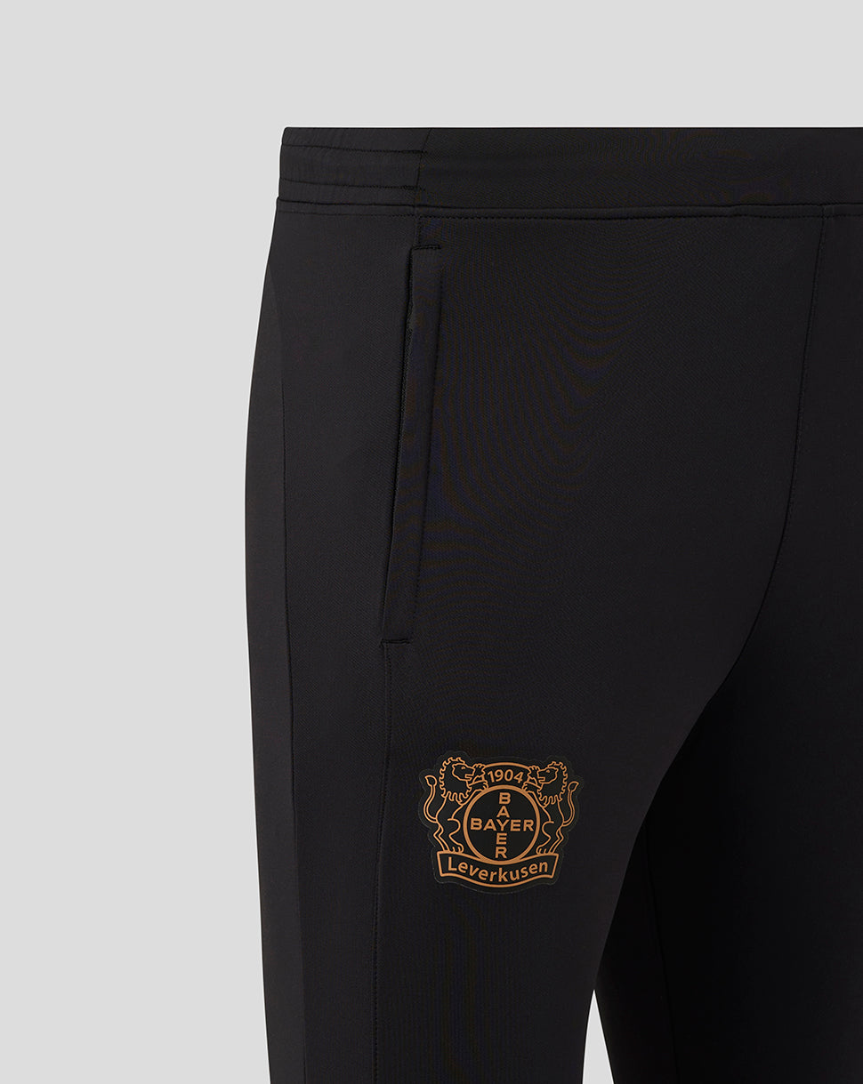 Close up of black training pants showing the gold Bayer Leverkusen crest on the side.