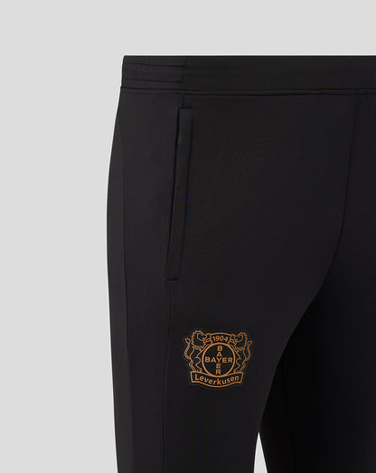 Close up of black training pants showing the gold Bayer Leverkusen crest on the side.