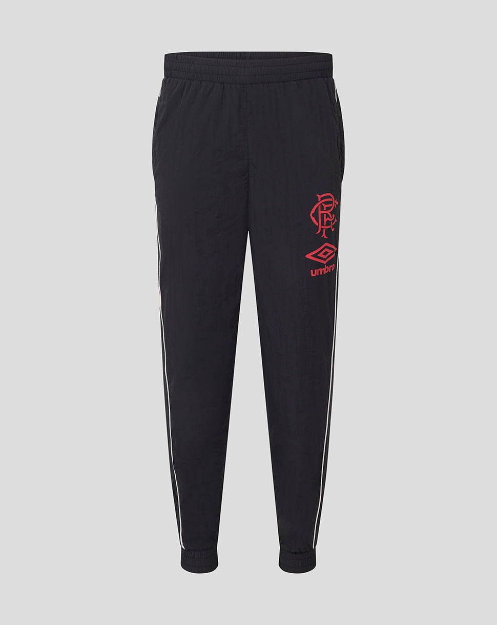 Front view of junior dark travel pants with elastic waistband white piping along the legs and red Rangers crest with Umbro logo.