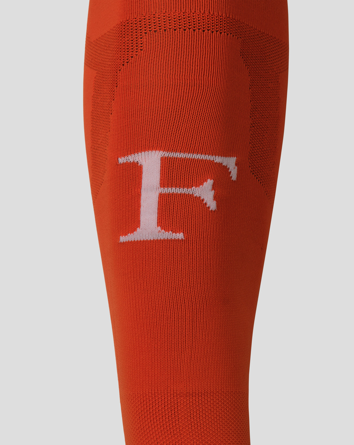 Close up of orange Feyenoord goalkeeper footless sock knit showing texture and white logo