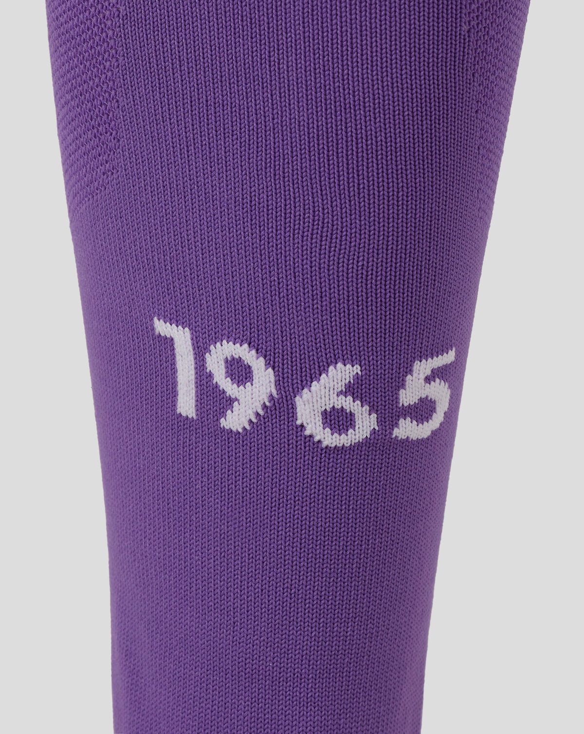 Close up of a purple FC Twente goalkeeper footless sock showing fine knit texture and a white graphic near the lower leg.