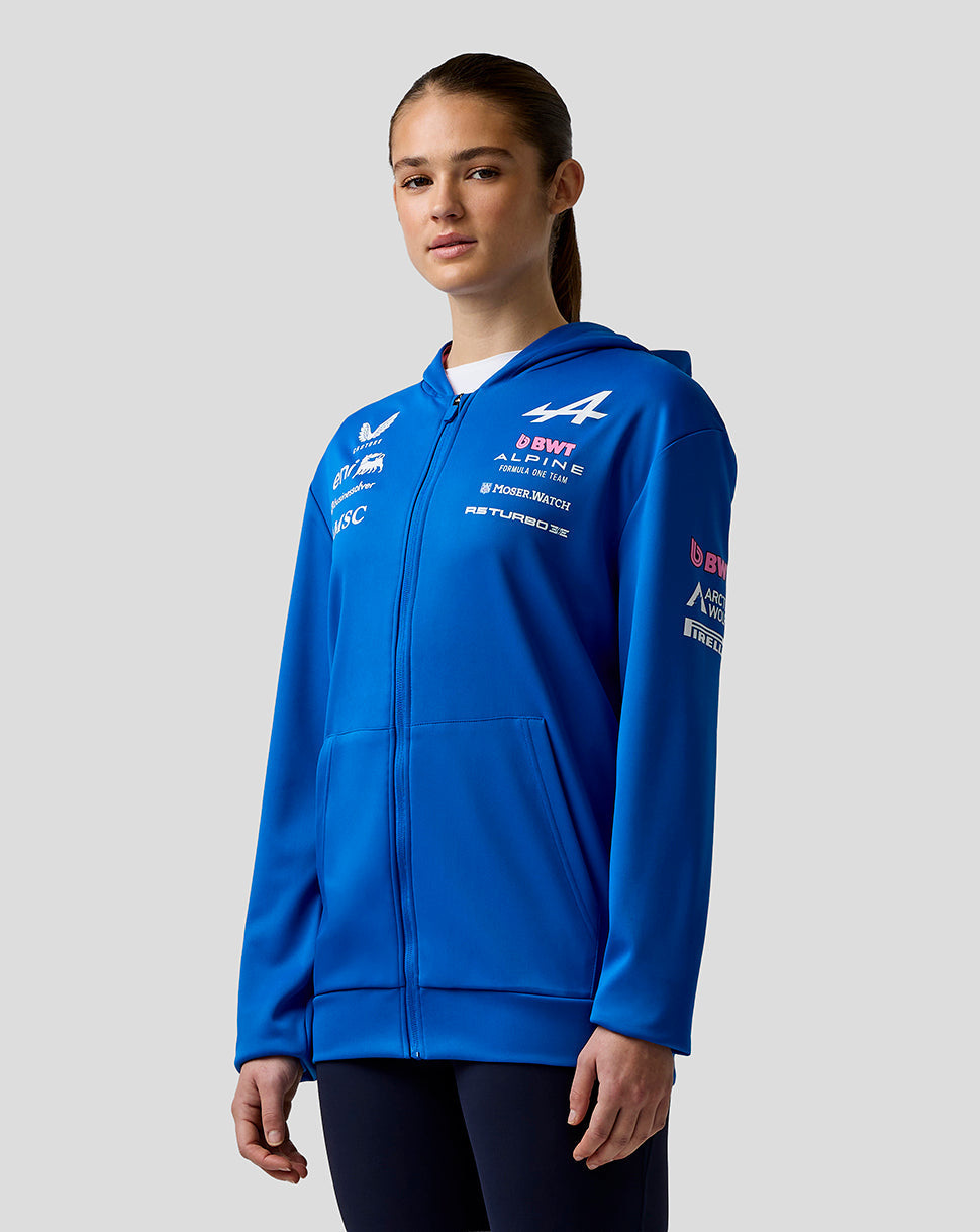 Blue official Junior BWT Alpine Formula One Team zip hoodie worn by a female model back view highlighting Alpine branding on the upper back