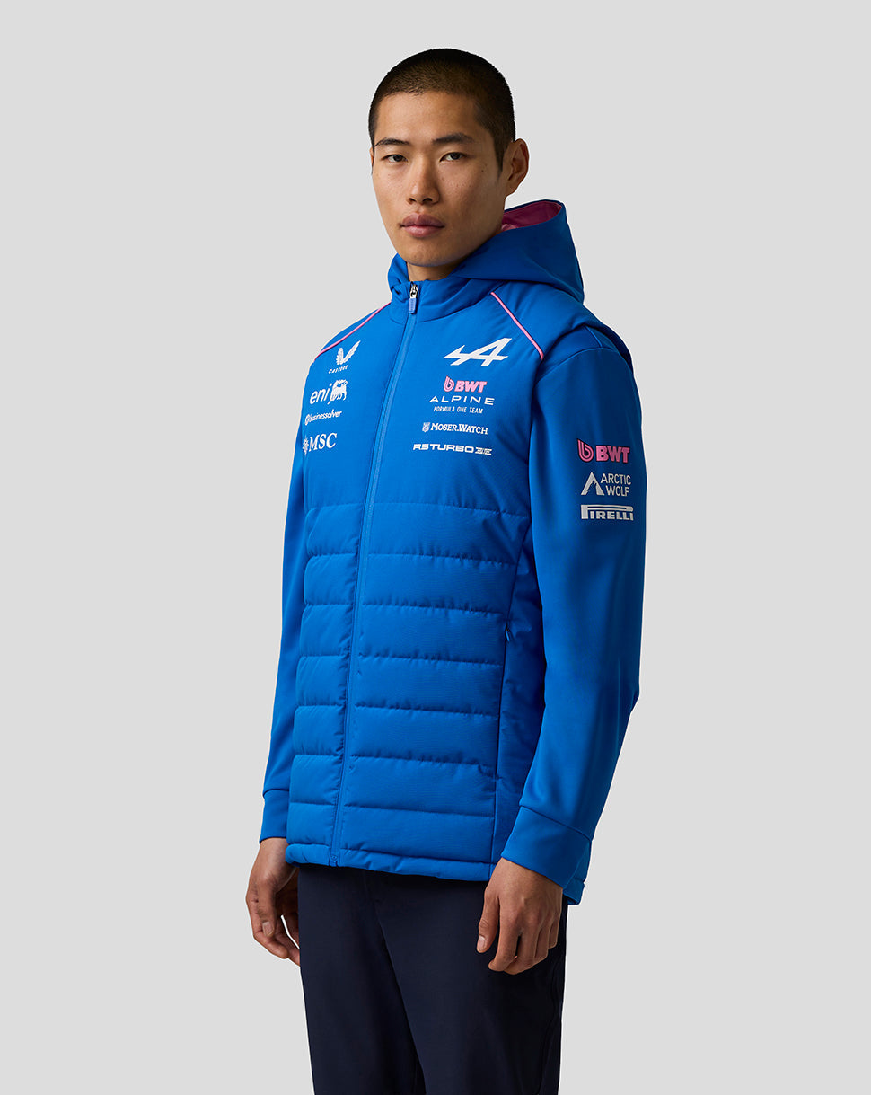 Model wearing blue BWT Alpine Formula One Team Gilet with hood and quilted panels and logos.