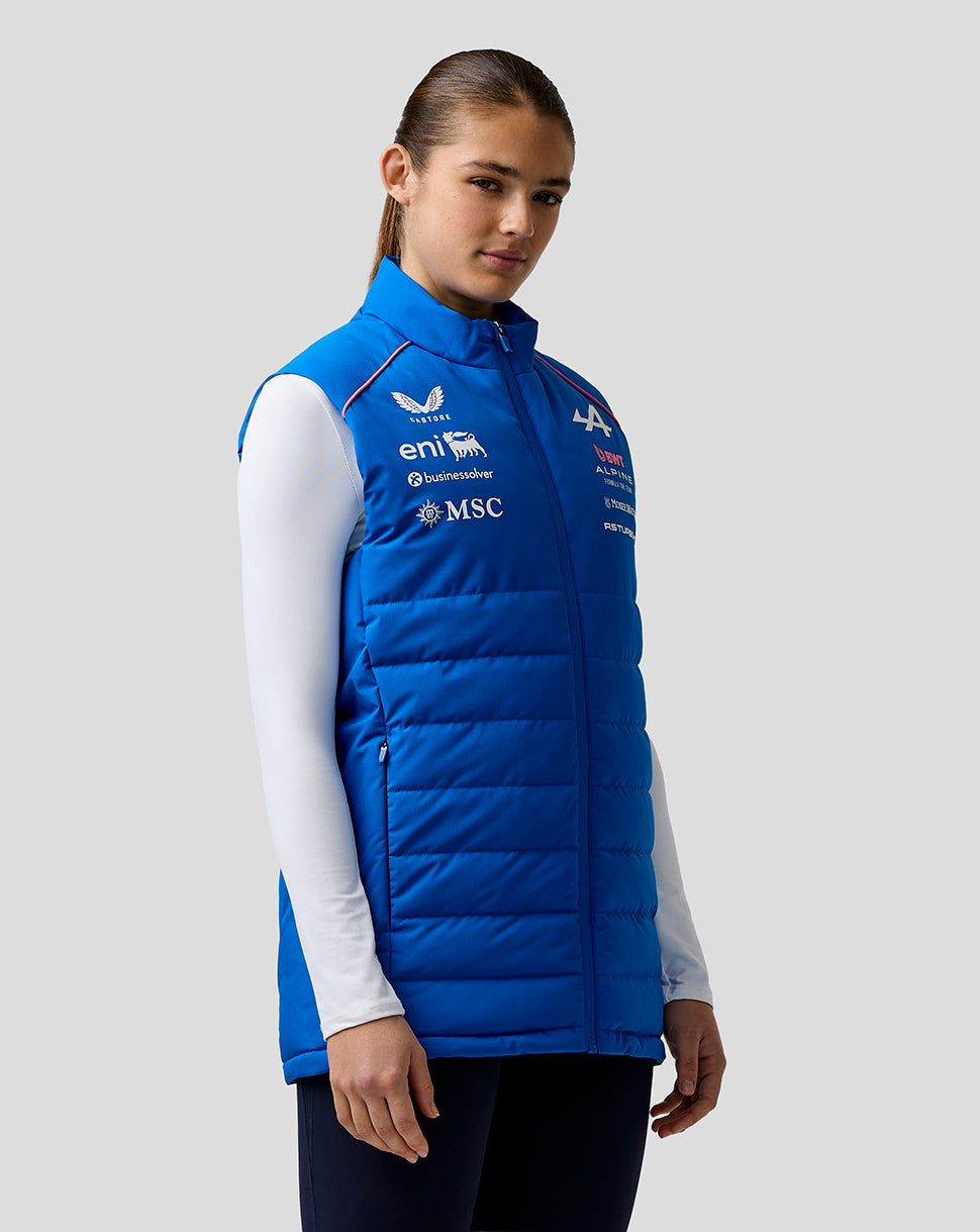 Female model wearing blue BWT Alpine Formula One Team Gilet with logo patches on chest.