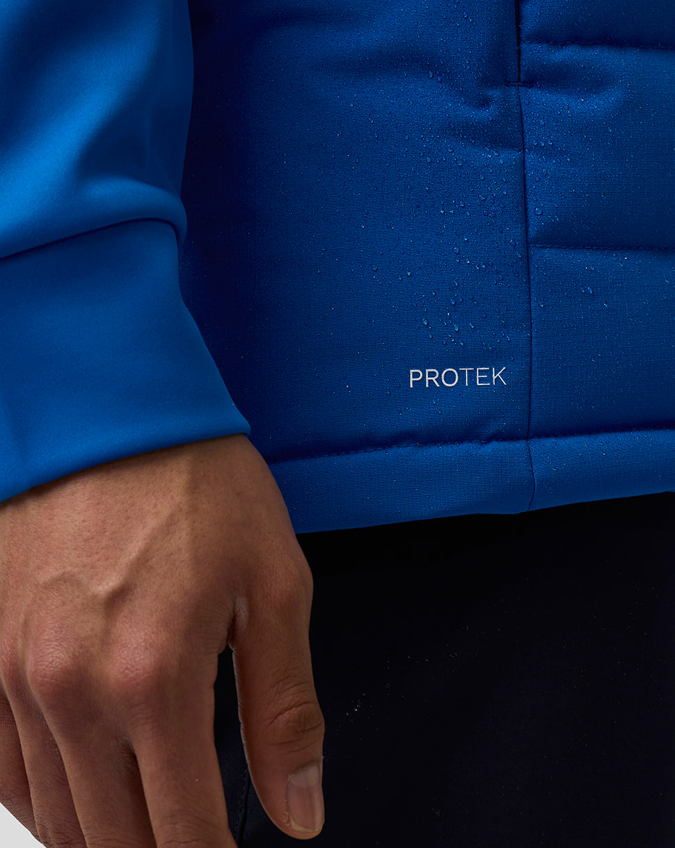 Close-up of blue BWT Alpine gilet fabric with ProTek logo and water droplets.