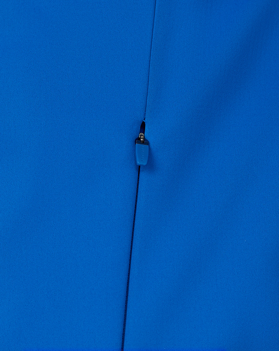 Detail of the center front zipper with blue pull on the blue soft shell jacket.
